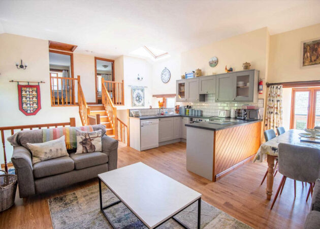 Open plan kitchen with dishwasher, microwave, fridge, electric oven and hob, full range of cooking utensils.